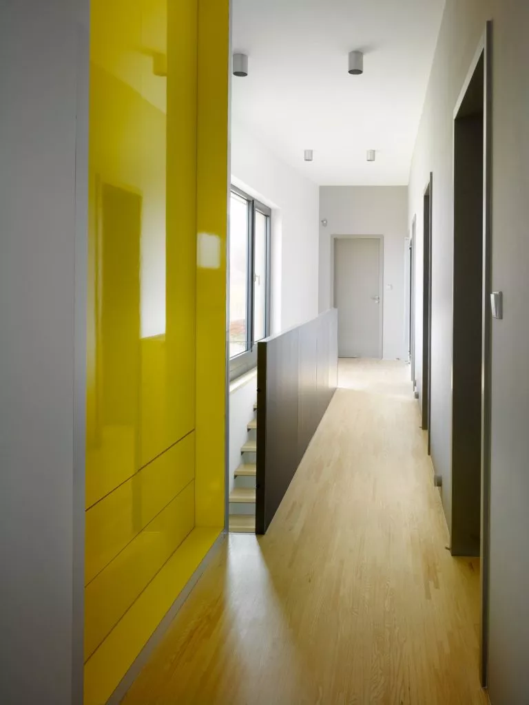 hallway with white plaster walls and a yellow cabinet