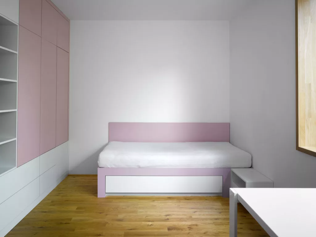 pohled na stěnu ložnice s růžovým nábytkem