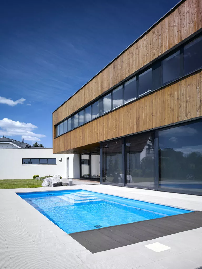 pohled na dřevěnou fasádu s bazénem na terase