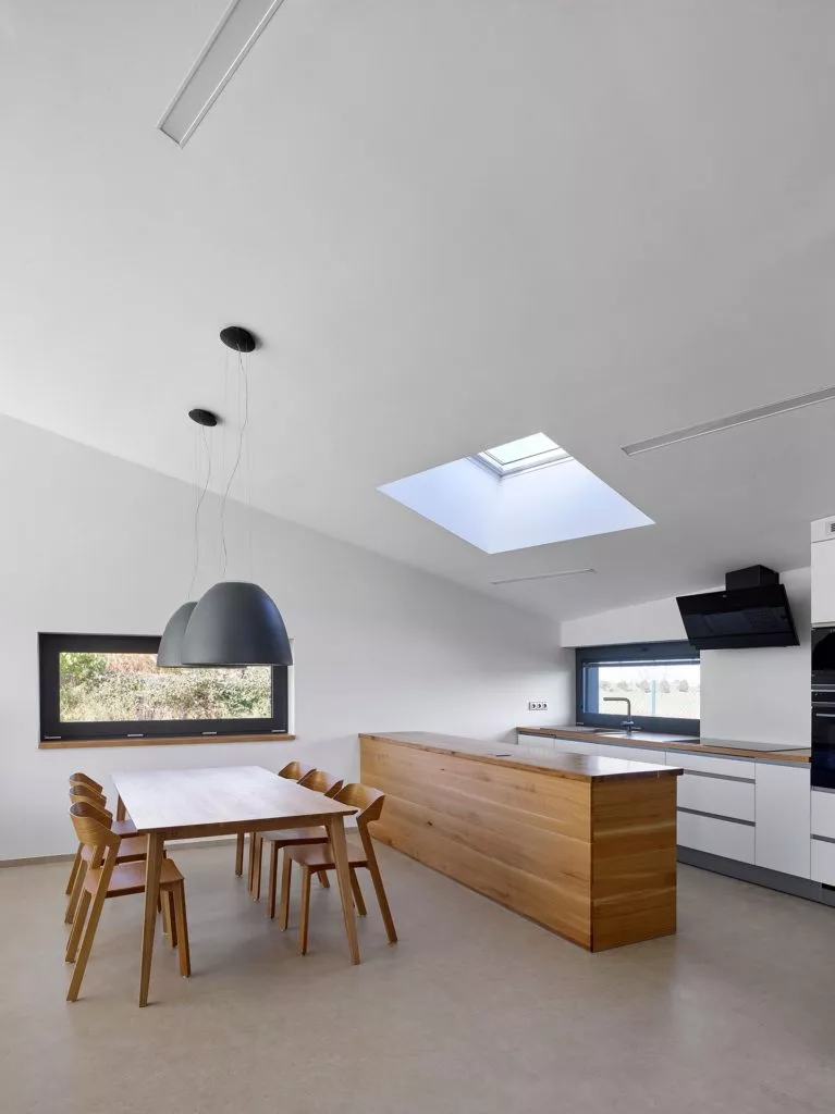 White kitchen interior with wooden furniture in a family house in Zelenec